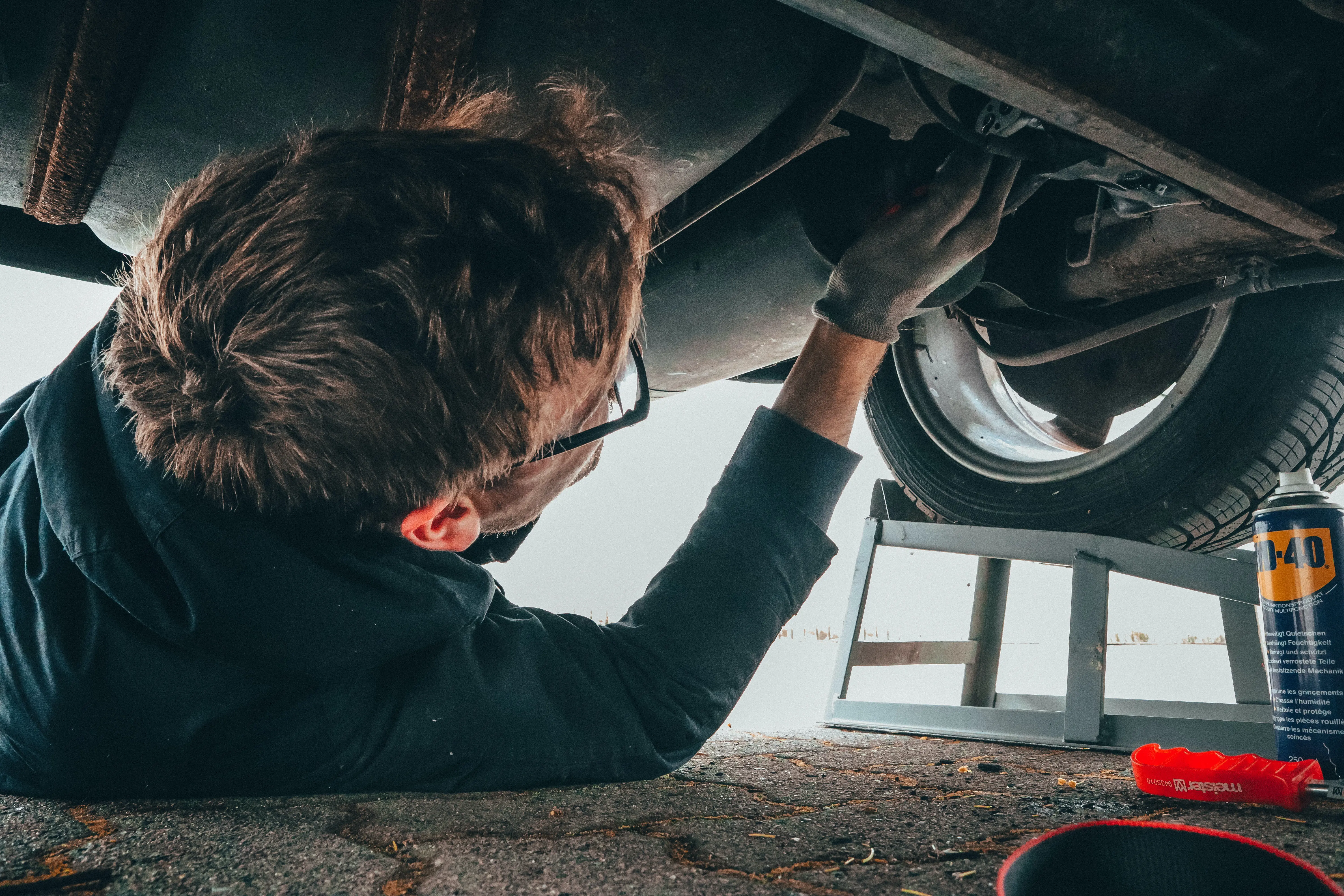 Some guy fixing some vehicle.